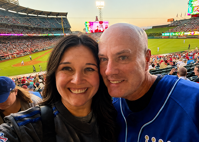 Brian Newby and his wife Jessica take a happy selfie at a professional baseball game.