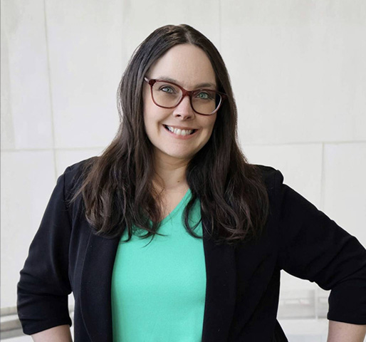 Professional headshot of Colleen wearing glasses, a teal top and black suit jacket.