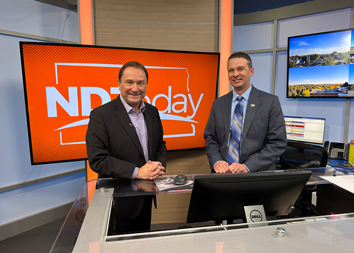 Josh Kadrmas and a KFYR-TV anchor pose for a picture in the studio following a Cybersecurity Awareness Month segment.