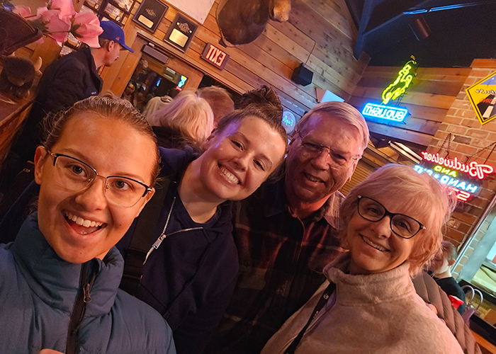 Julie Arp huddles together with her happy family for a group pictures while out together for a fun evening.