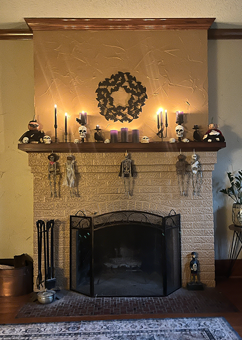 Skeletons, skulls, bats, candles, and other Halloween decorations adorn Monique Durgin’s fireplace.