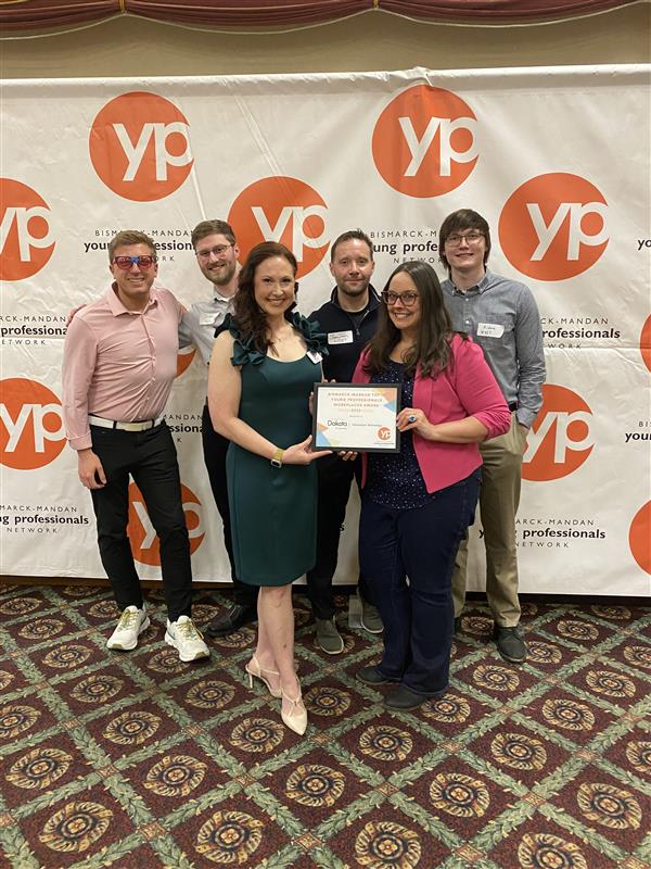 Four NDIT men and two women gather for a picture with their Top 10 Young Professional Workplaces award from the Bismarck-Mandan YPN.