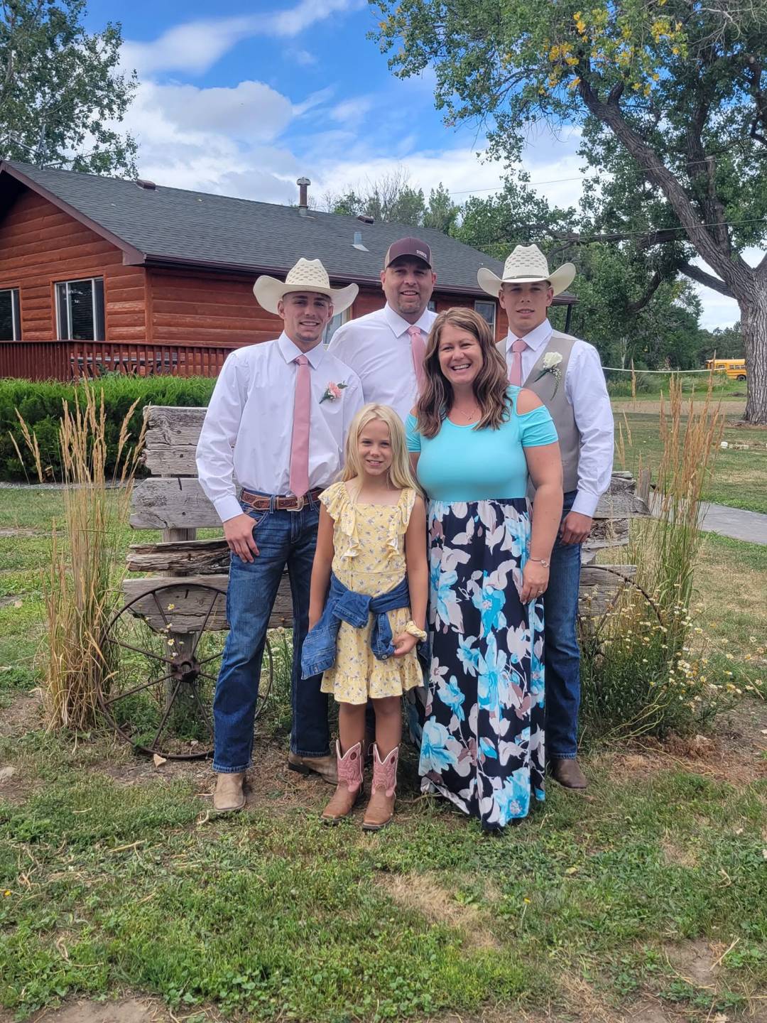 Tina Radenz, her husband, their two sons, and young daughter pose for a family pic at a farmstead on a beautiful summer day.