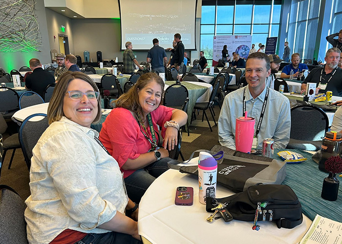 Tina Radenz poses for a picture with a couple of Security colleagues during an all-employee meeting at Gateway to Science.