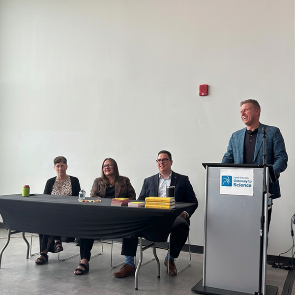 Members of NDIT’s leadership team share a laugh at the front of an event space during an all-employee gathering.