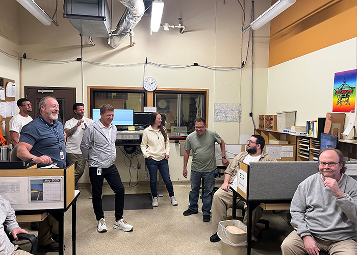 Gathered in the AutoCAD room at DOCR in Bismarck, ND, Dave Sission and prison residents share a laugh with NDIT visitors.