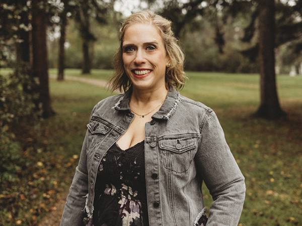 Jessy Wetsch's professional headshot with her wearing a black flowered blouse and grey, jean jacket.