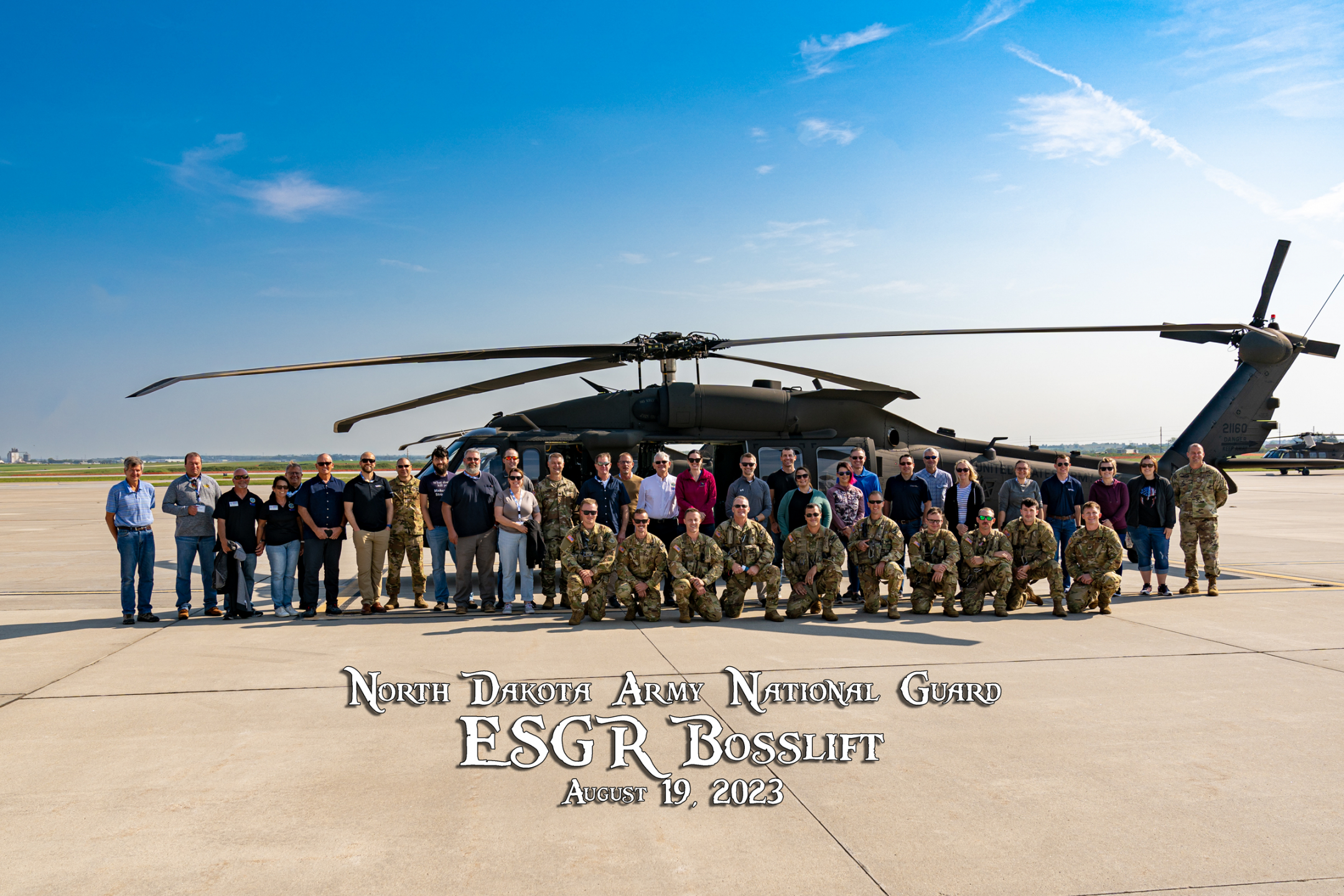 North Dakota Army National Guard ESGR Bosslift 2023 group photo in front of a Helicopter