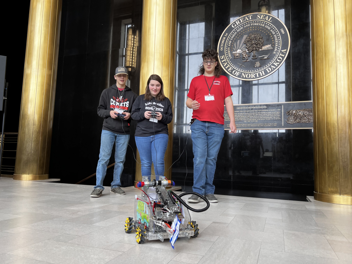 Alexander Public School students Garrett, Peiten, and Austin display their hand-built robot.